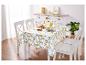 Nappe à motif citron et chaises blanches pour une table de salle à manger.