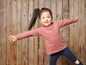 Une petite fille portant un t-shirt rayé et des leggings bleus avec un motif léopard.