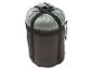 Un sac de couchage dans un sac de compression avec des sangles.