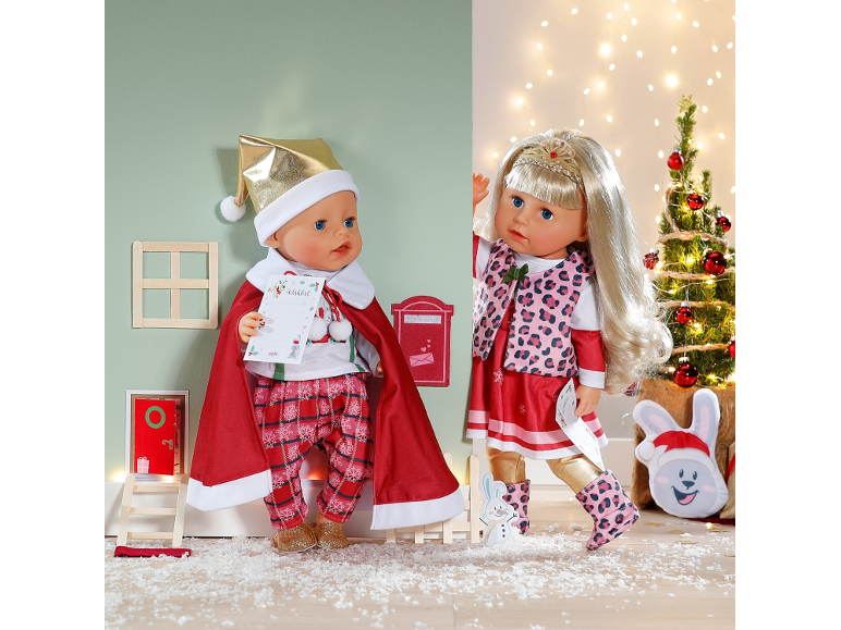 Deux poupées sur le thème de Noël en tenues de fête dans un décor d'hiver ludique.