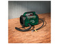 Un compresseur d'air Parkside X20V Team vert avec un tuyau sur une table en bois.