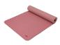 Un tapis de yoga rose de Crivit, enroulé.