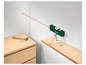 Un niveau laser vert Parkside sur un trépied, qui projette une ligne rouge sur le mur.