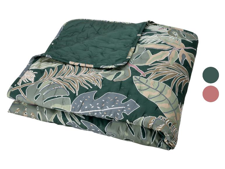 Jeté de lit matelassé à motif de feuilles tropicales dans les tons verts et beiges.