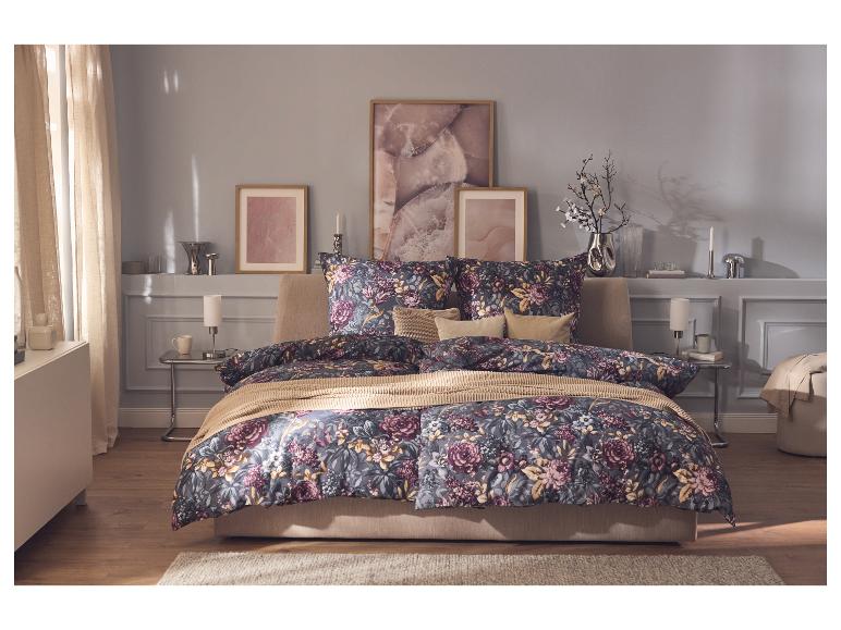 Chambre avec un lit à la literie florale, des tableaux et des lampes de chevet.