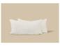 Deux oreillers blancs en tissu froissé sur un fond beige.