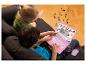 Deux enfants jouent avec un ordinateur portable rose Lexibook Disney Princess sur un canapé.