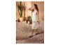 Femme en robe en maille vert clair et chaussures plates noires, marchant dans un patio avec des cactus.
