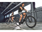 Deux personnes à vélo électrique dans un environnement intérieur.