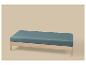 Banc en bois avec coussin bleu-vert sur fond beige.