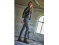 Femme en veste en cuir noire et jeans portant des bottes de combat noires.