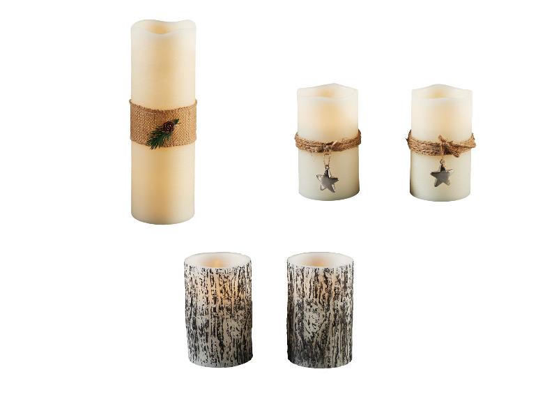 Diverses bougies LED, dont une grande avec une corde de jute et une pomme de pin, deux plus petites avec un pendentif étoile et deux avec une texture d'écorce.
