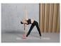 Femme en leggings noirs et soutien-gorge de sport pratiquant le yoga sur un tapis avec un bloc de yoga.