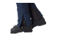 Pantalon de ski bleu avec fermetures éclair et chaussures de ski noires.
