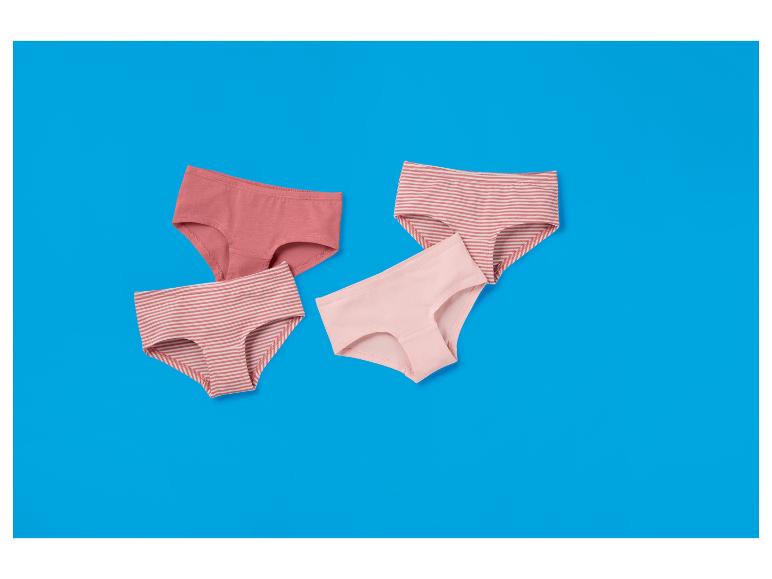 Quatre culottes pour femmes dans des tons roses, dont deux rayées, sur fond bleu.
