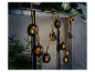 Guirlande lumineuse extérieure avec lanternes noires décoratives.