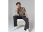 Homme portant une chemise à imprimé, un pantalon noir et des baskets blanches Vans.