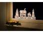 Silhouette de Noël lumineuse pour fenêtre avec maisons et sapins sur un rebord