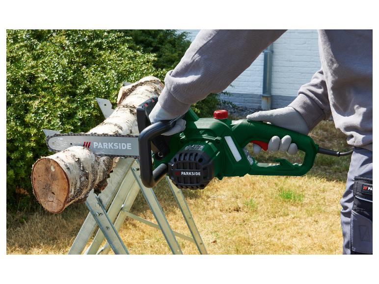 Personne coupant une bûche avec une tronçonneuse électrique verte Parkside sur un tréteau.