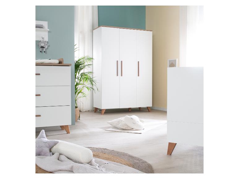 Une chambre de bébé moderne avec des meubles blancs et en bois, incluant une commode, une armoire et un lit de bébé.