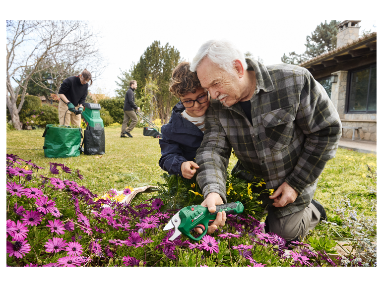 Un grand-père et son petit-fils utilisent des ciseaux de jardin Parkside pour tailler des fleurs.