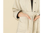 Une veste en jean beige avec une ceinture.