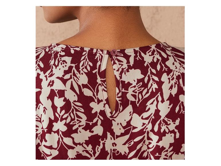 Un chemisier rouge foncé à imprimé floral blanc.