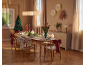 Salle à manger de Noël avec table décorée, chaises avec nœuds et décor mural festif.