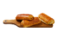 Trois pains au chocolat dorés sur une planche à découper en bois.