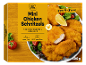 Boîte de mini-schnitzels de poulet avec une assiette de schnitzels cuits, citron et salade.