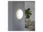 Un luminaire mural rond dans un intérieur moderne avec un canapé et une table basse.