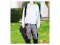 Une personne portant un sweat-shirt gris et un pantalon de travail transporte un souffleur à feuilles Parkside Performance.