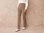 Pantalon beige avec des baskets blanches.