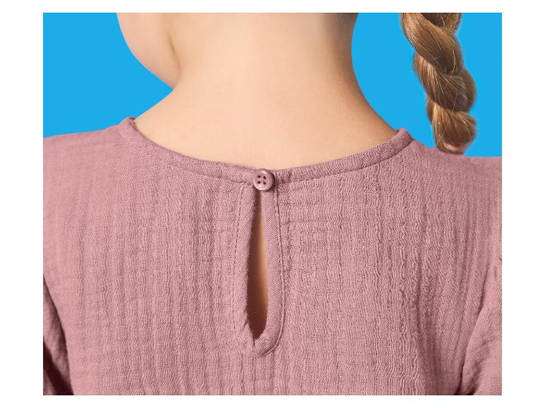 Dos d'un chemisier rose pour enfant avec un bouton au cou et une tresse