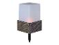 Une lampe blanche carrée avec un revêtement en rotin et une pointe pour le sol.