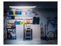 Un garage avec un vélo, des valises, des outils et une lampe LED.