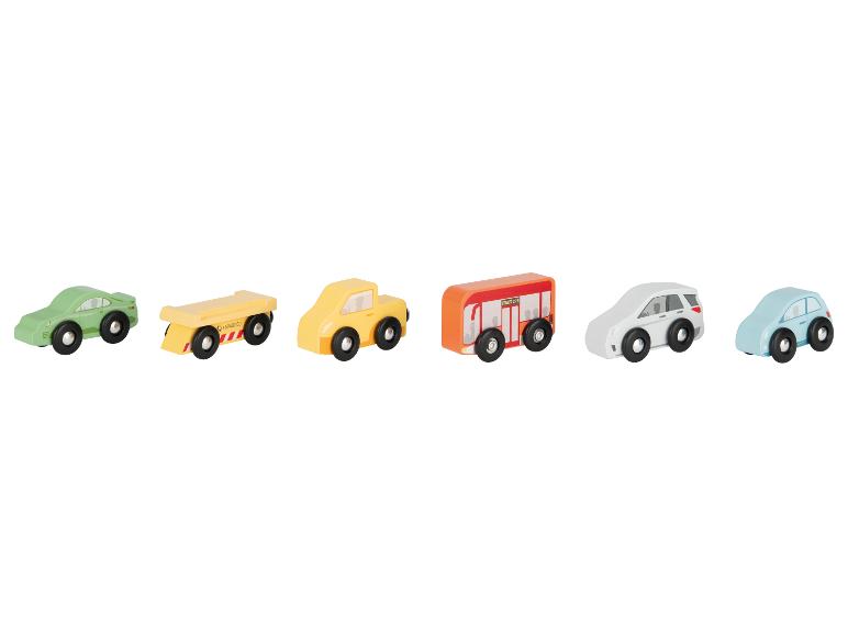 Une rangée de voitures jouets en bois colorées, dont une voiture verte, un camion jaune, un bus orange et deux voitures particulières.