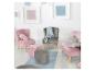 Chambre d'enfant avec des chaises en velours rose et gris, des poufs et des tableaux au mur.