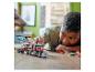 Un enfant joue avec un camion LEGO avec un hélicoptère dessus.