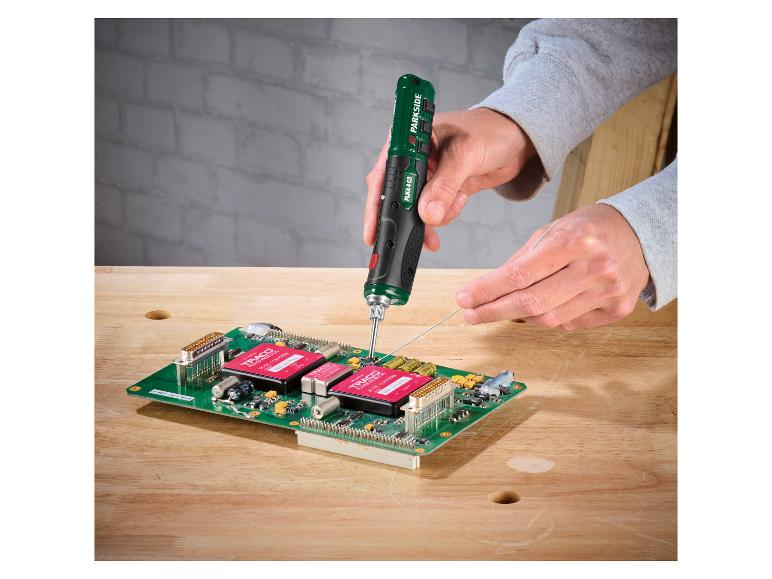 Un fer à souder électrique manuel soudant une carte de circuit imprimé avec des composants électroniques.