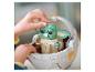 Une personne assemble une figurine LEGO Star Wars Grogu dans un landau.