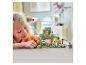 Une fille souriante joue avec un ensemble LEGO Friends, un centre de sauvetage pour animaux.
