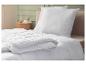 Couette et oreiller blancs sur un lit dans une chambre avec table de chevet.