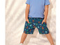 Un enfant porte un t-shirt bleu et un short à imprimé palmiers.