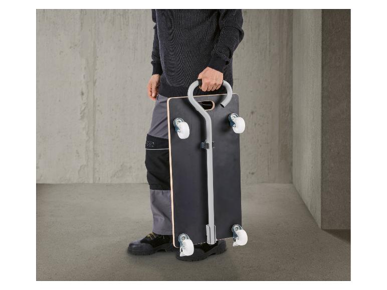 Homme tient un chariot de transport avec poignée, prêt à l'emploi.