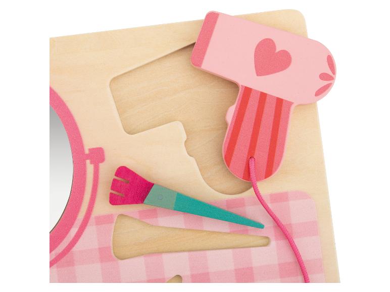 Jouet en bois avec sèche-cheveux, brosse et miroir dans des tons roses.