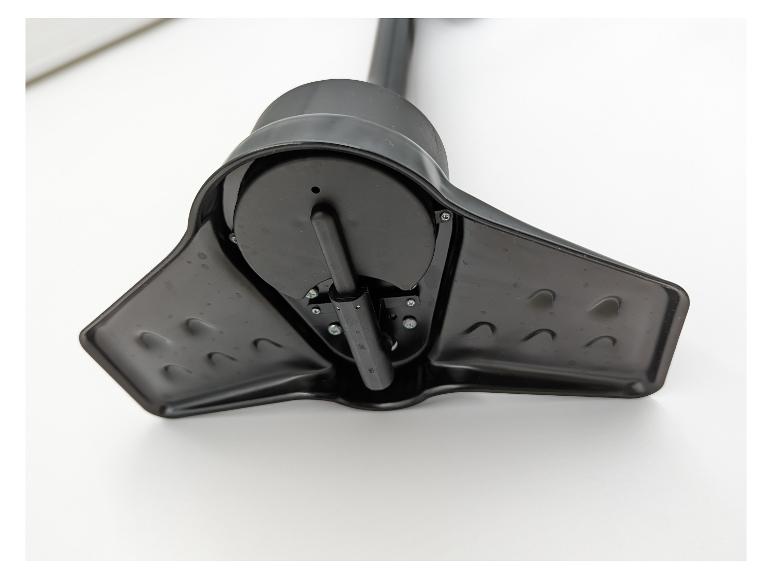 Gros plan d'une base en plastique noir avec mécanisme rotatif central et vis