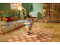 Enfant sur cheval à bascule dans une chambre d'enfant sur le thème de Noël avec lit et étagères.