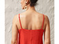 Une femme porte une robe rouge à bretelles fines.