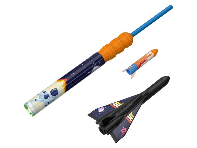 Trois fusées jouets différentes, une avec un design d'astronaute, prêtes pour le lancement.